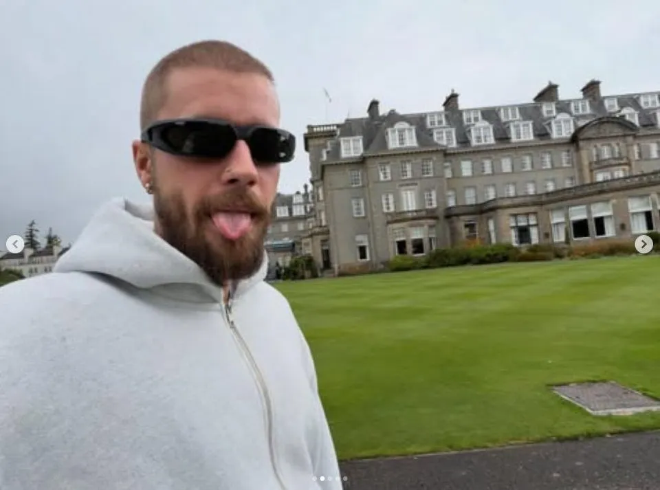 Justin Bieber posing for a selfie in front of a luxury hotel in Scotland.